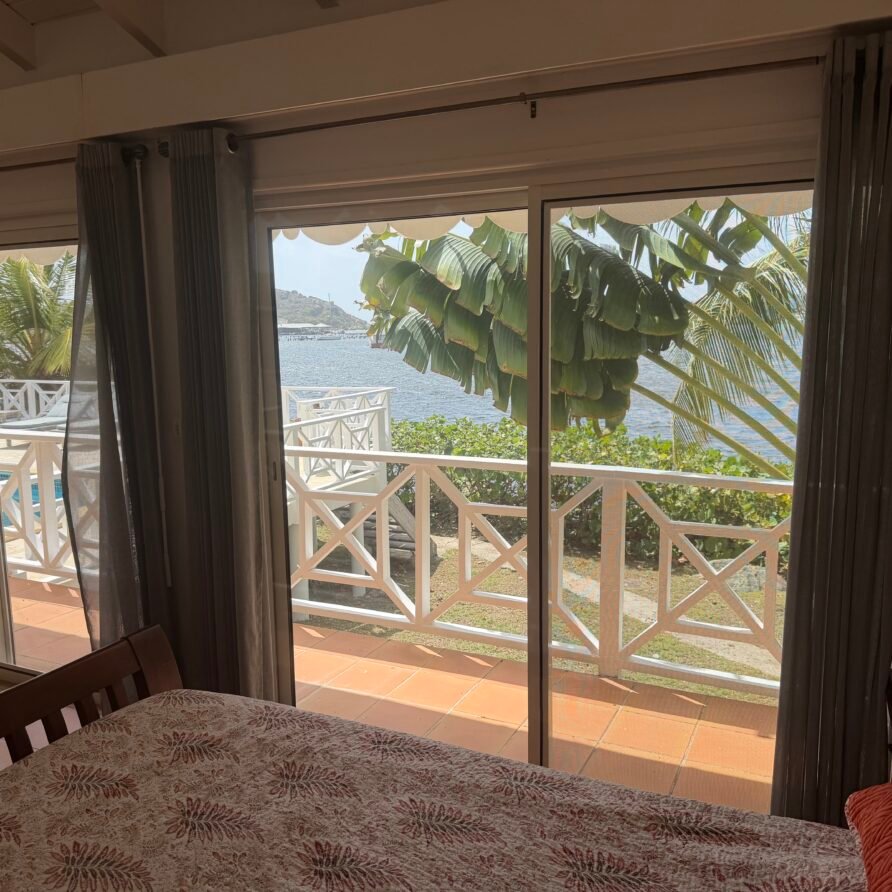 Spacious waterfront villa with a large pool deck, lounge chairs, and panoramic sea views.