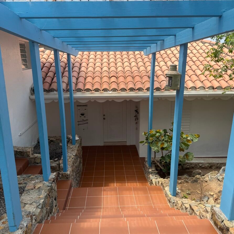 Spacious waterfront villa with a large pool deck, lounge chairs, and panoramic sea views.