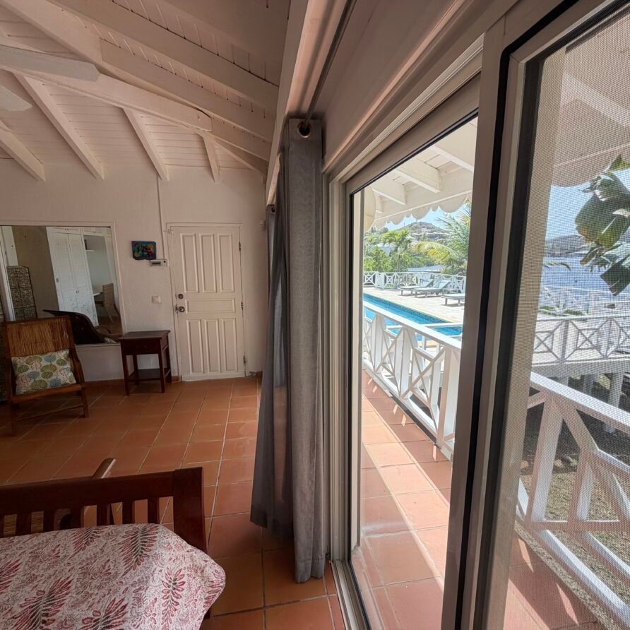 Spacious waterfront villa with a large pool deck, lounge chairs, and panoramic sea views.